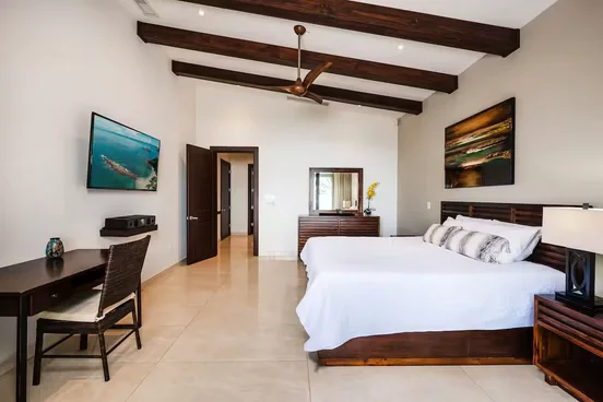 Private room with a king bed, wood-beamed ceiling and desk